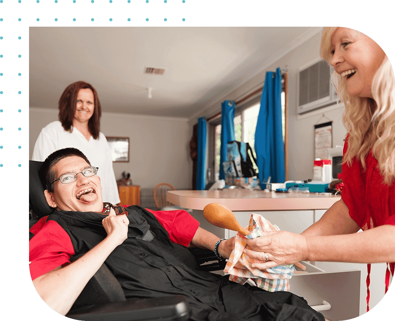 A man in wheelchair smiling at another person.
