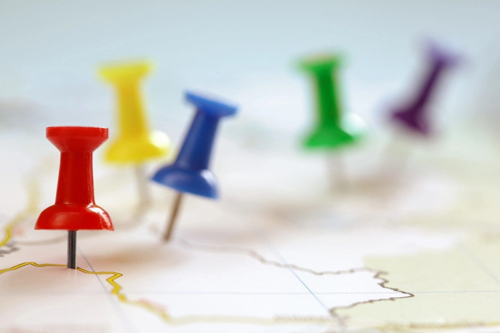 Colorful pushpins on a blurred map.