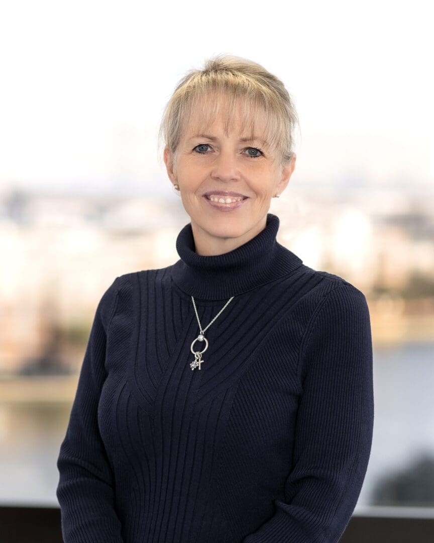 Portrait of woman wearing pendant near water